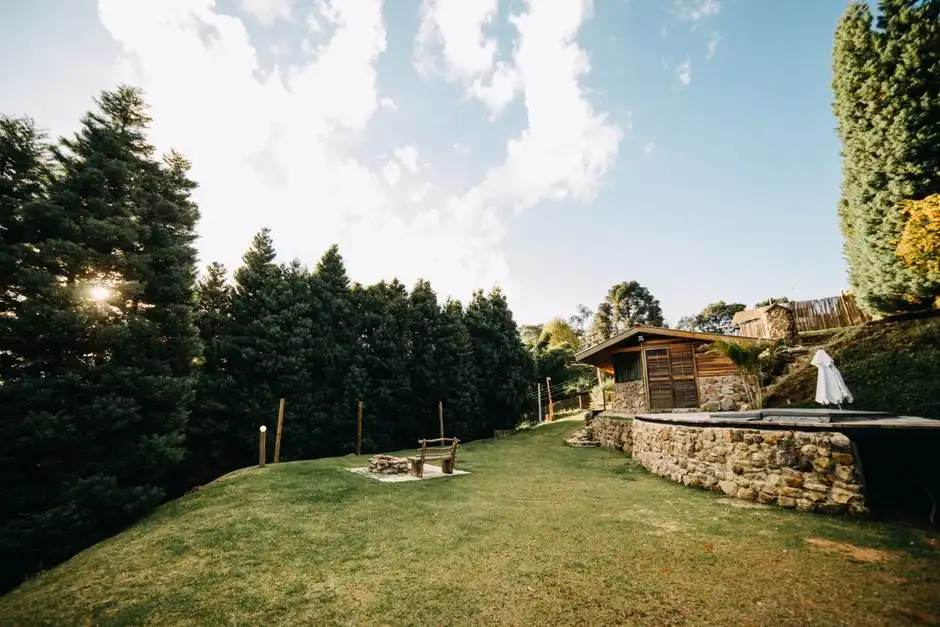 Quintal gramado com casa de campo ao fundo